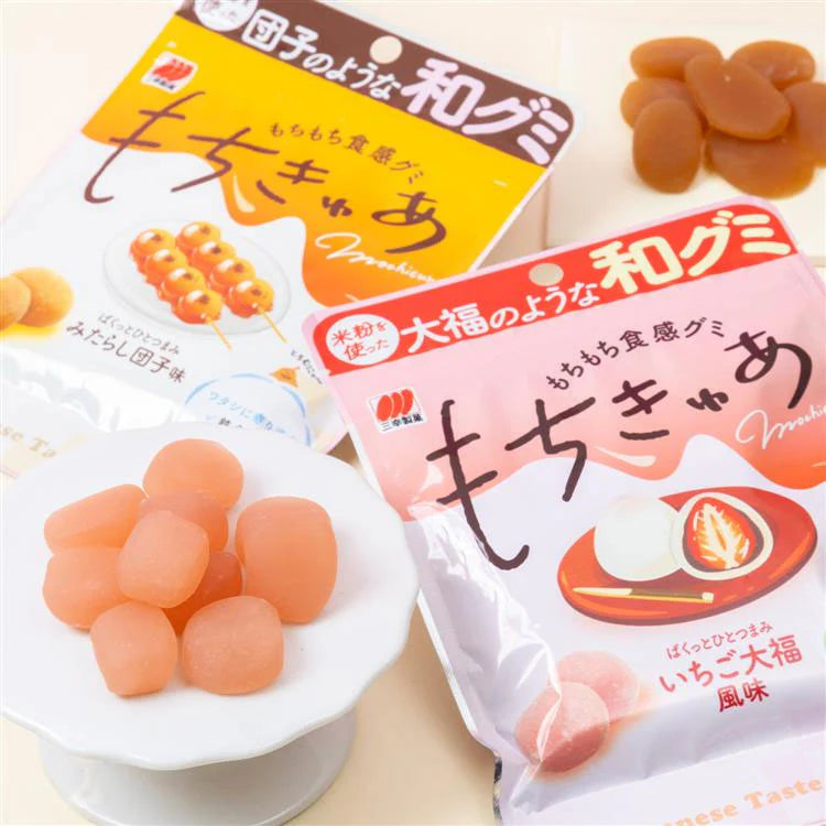 Portrait image of the opened SANKO Seika Mochicure Strawberry Daifuku gummies displayed beside the package, highlighting their soft, mochi-like texture and strawberry-inspired appearance.