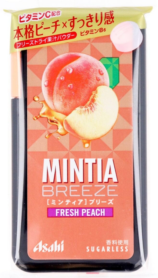 Portrait image of the ASAHI Mintia Breeze Fresh Peach mint tablets pack, shown unopened on a white background with peach-themed graphics and a pink design.