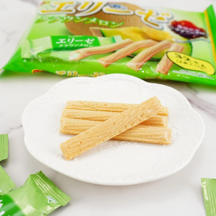 Bourbon Elise Crown Melon wafers arranged on a plate with additional wafers beside the plate, showing their crisp texture and creamy filling.