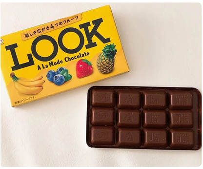 Back-facing landscape image of the closed FUJIYA Look A La Mode Chocolate 12 Packs box with assorted chocolates displayed outside the packaging on a white background.