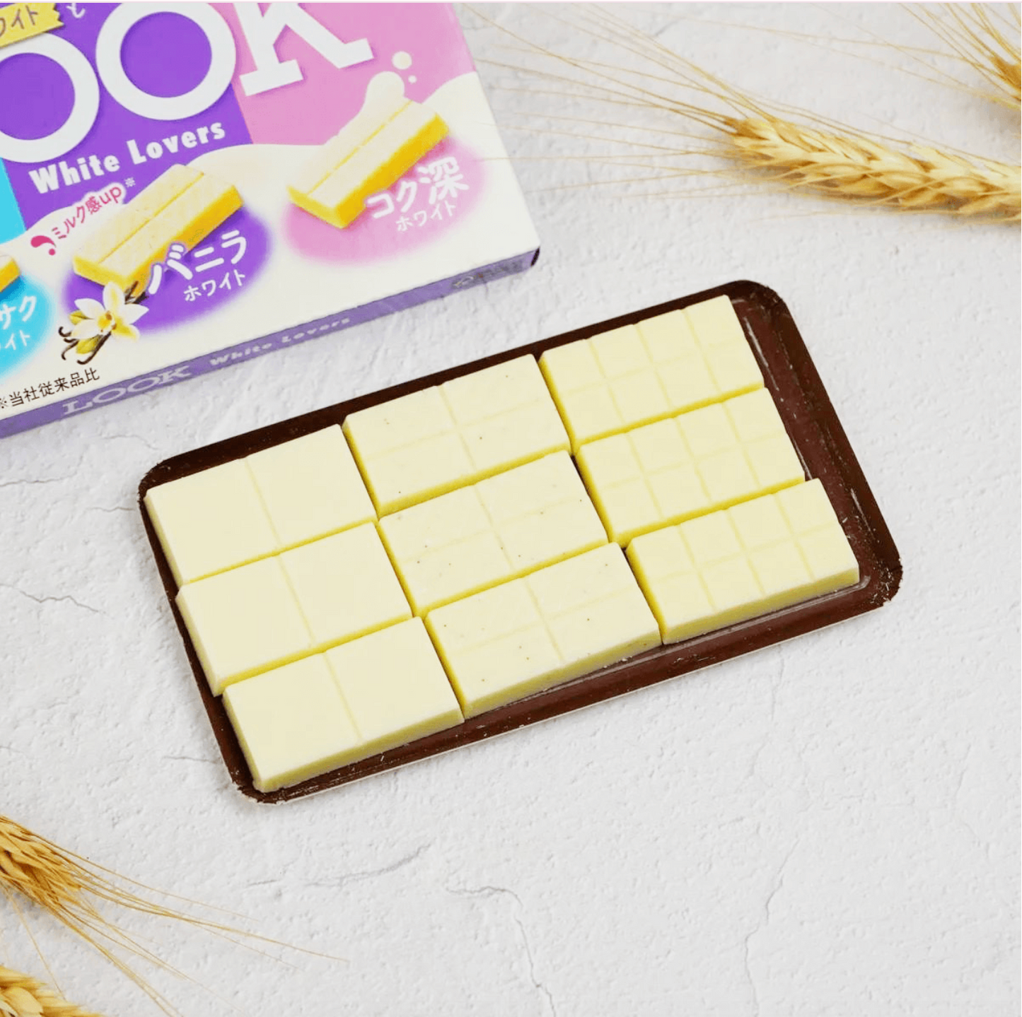 FUJIYA Look White Lover white chocolate pieces shown outside of the packaging, highlighting the smooth white chocolate appearance.