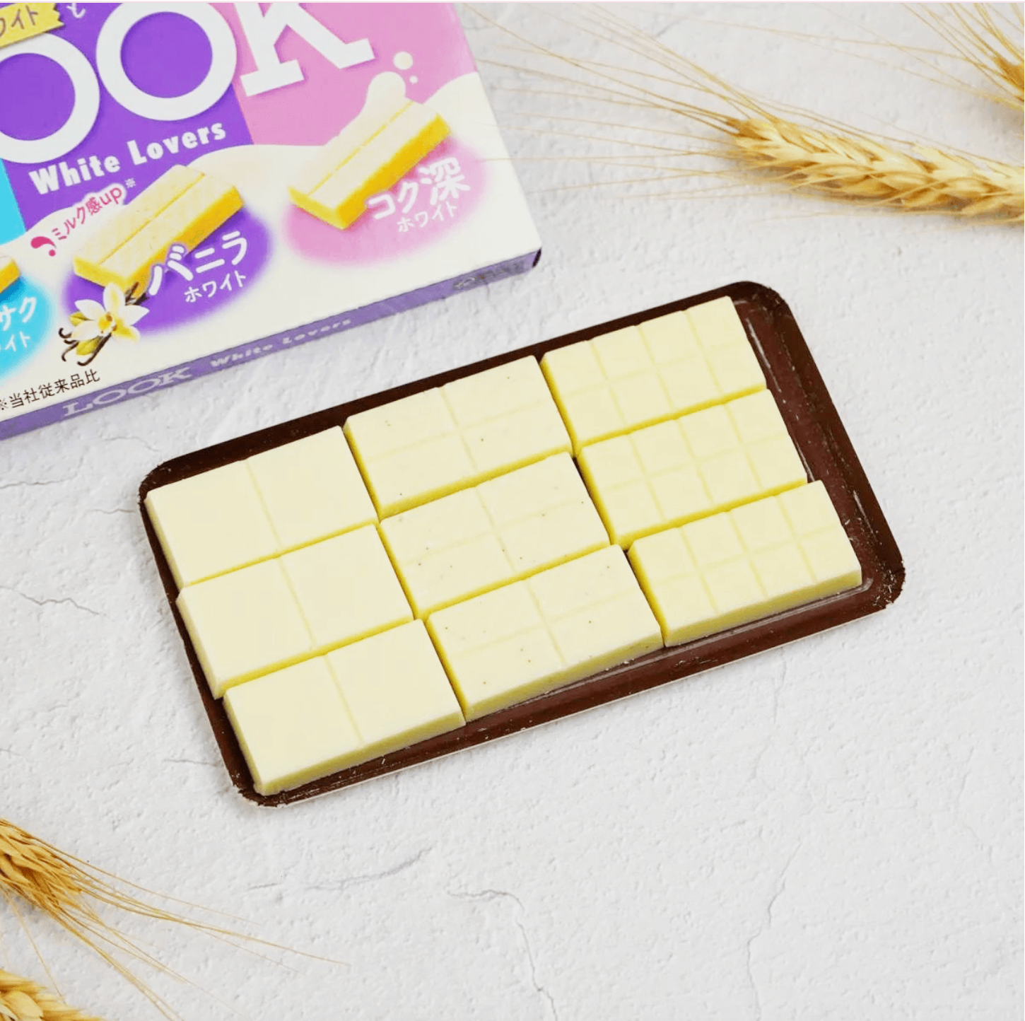 FUJIYA Look White Lover white chocolate pieces shown outside of the packaging, highlighting the smooth white chocolate appearance.