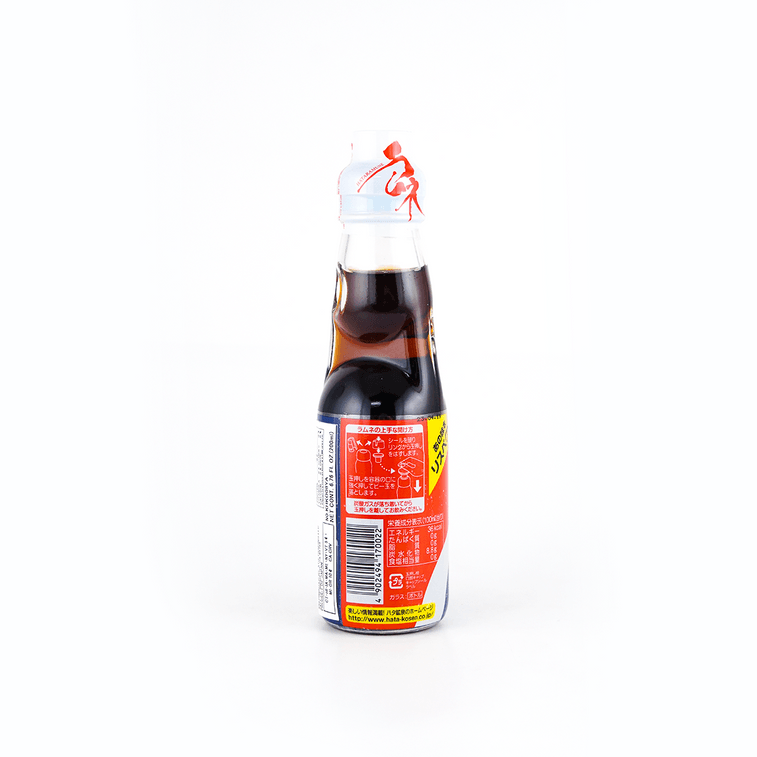 Back view of the HATAKOSEN Cola Ramune Soda 6.76 fl oz bottle, displaying product information and label details on the unopened bottle over a white background.