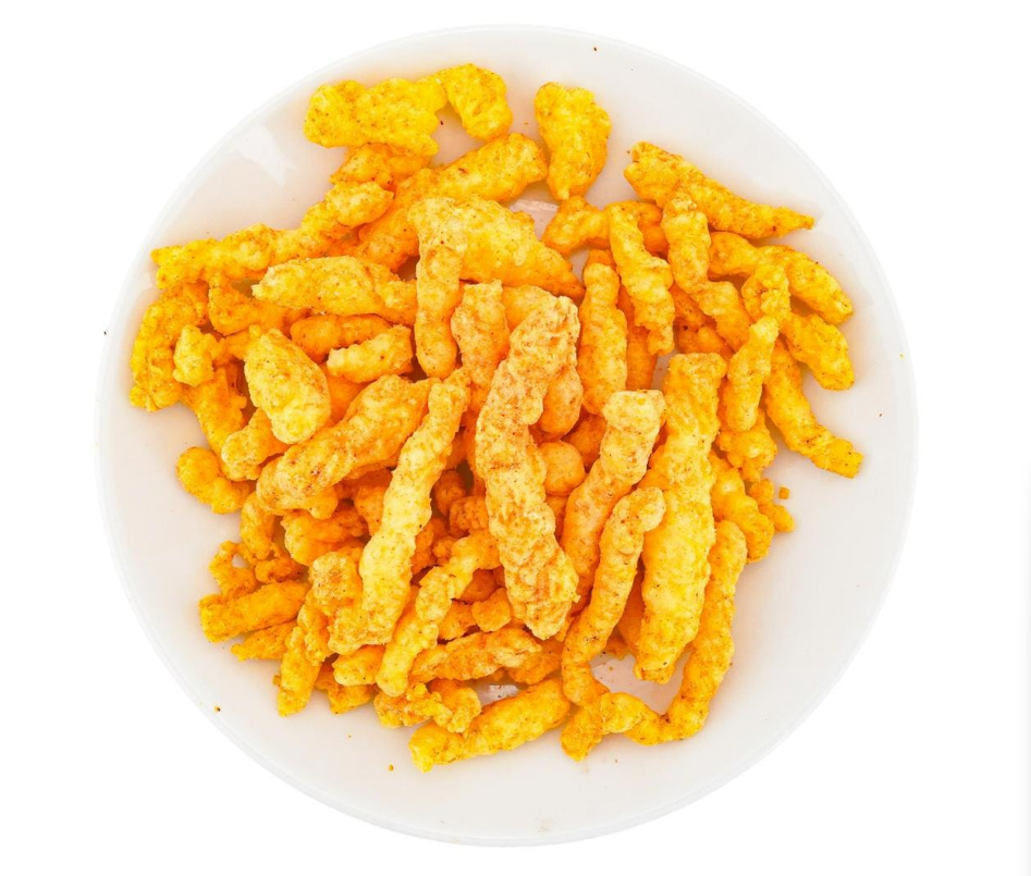 Sweet and spicy Cheetos corn snacks from the LOTTE Fritolay 82g bag displayed outside the packaging, showing their crunchy texture.