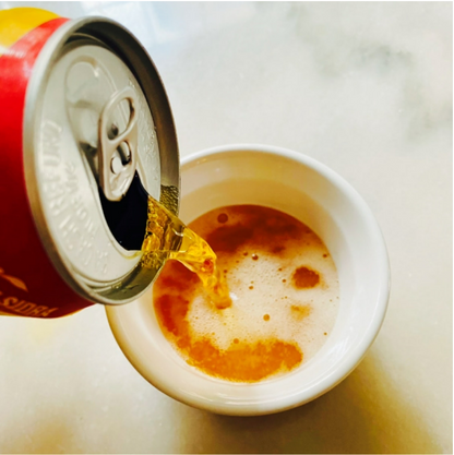 Image showing the Apple Sidra apple soda poured into a cup, highlighting its fizzy golden color and bubbly carbonation.
